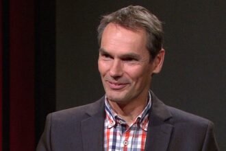 Man in blazer with checkered shirt.