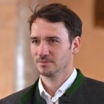 Man in formal attire, indoor setting.