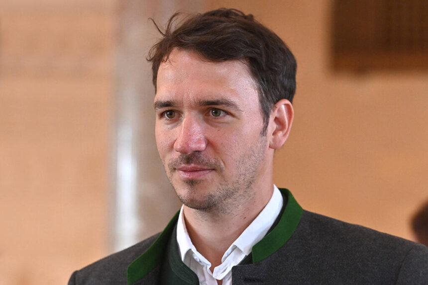 Man in formal attire, indoor setting.