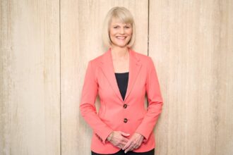 Smiling woman in coral blazer